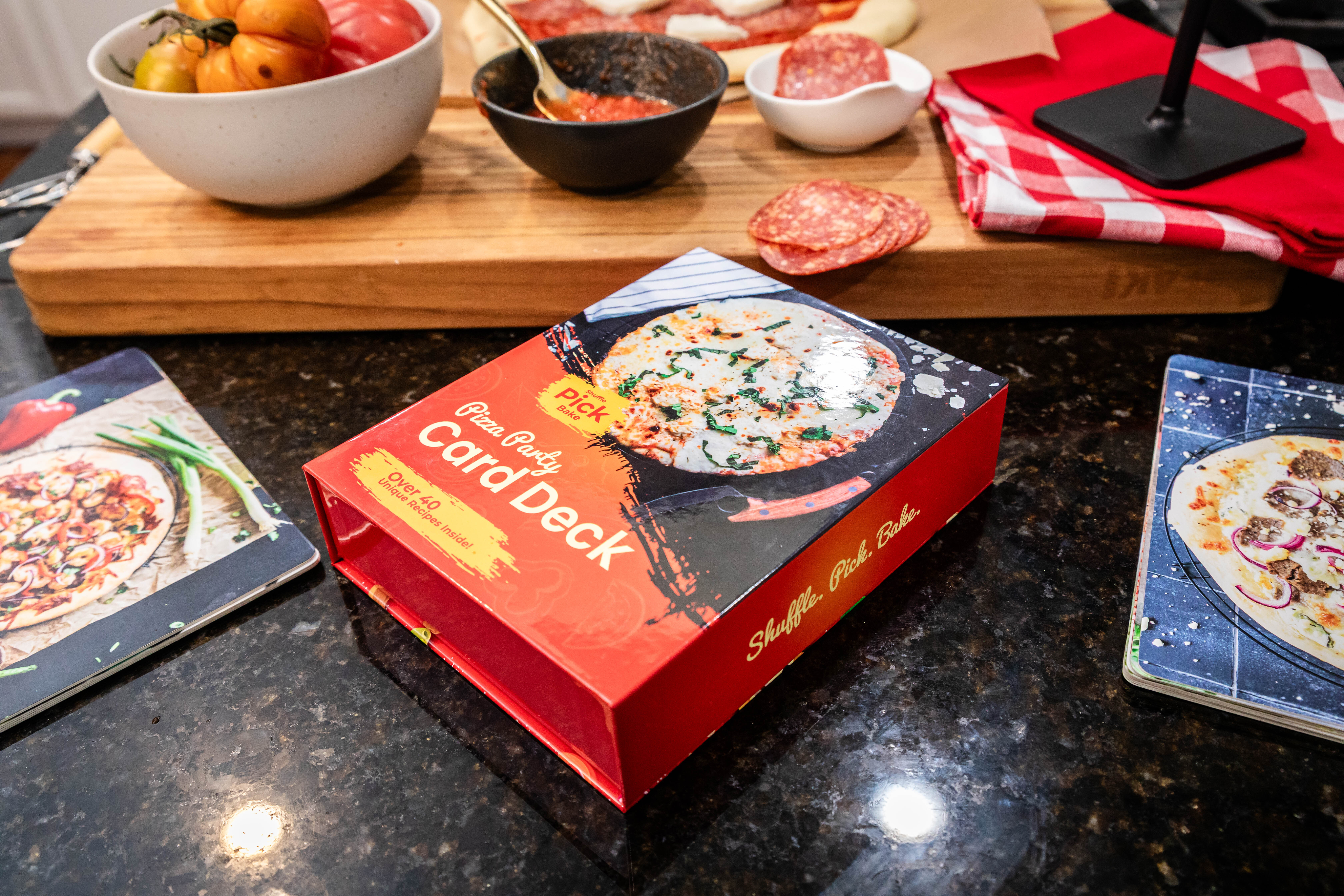The Pizza Party card deck on a kitchen counter mid pizza night